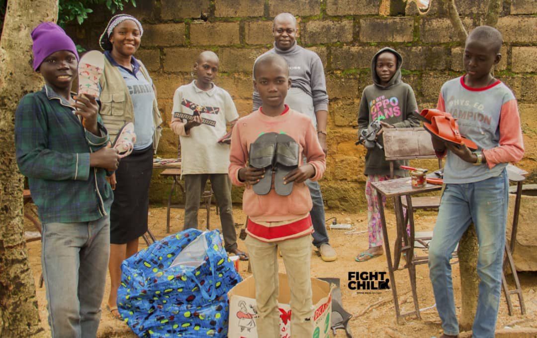 Children holding new shoes during JOFIN's Project Foot a Child outreach