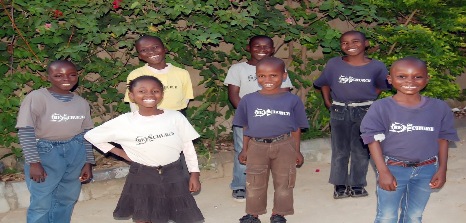 Smiling children in matching T-shirts standing together outdoors