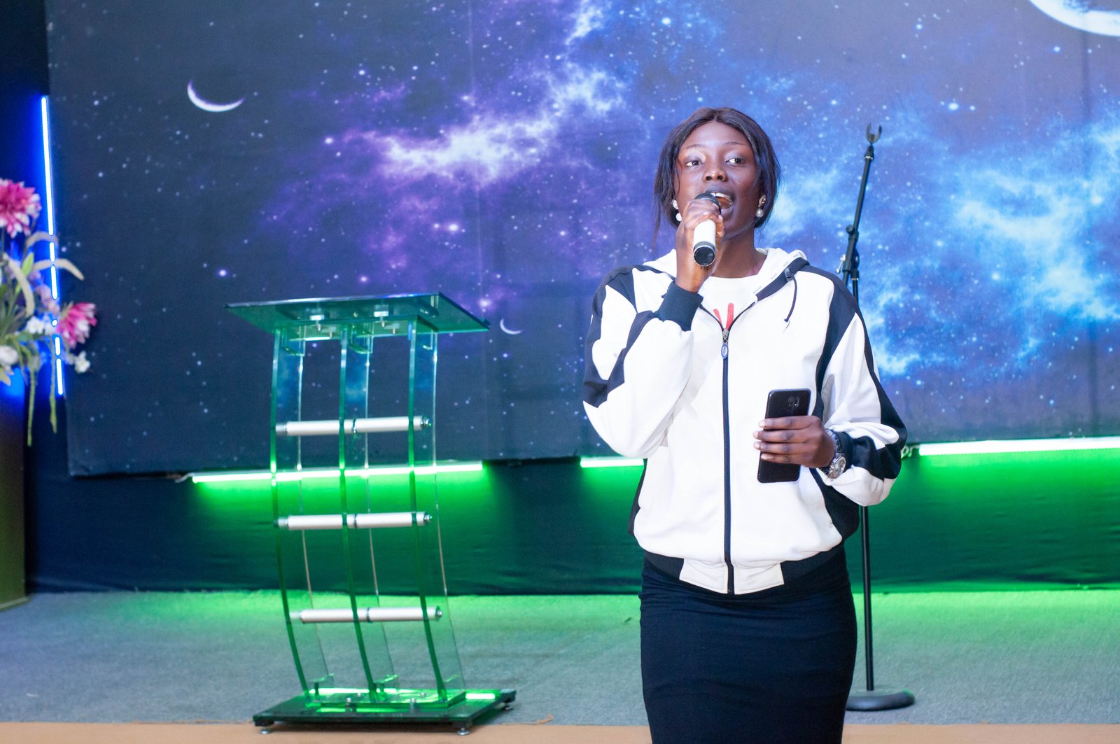 A young woman speaking to the audience at a JOFIN event