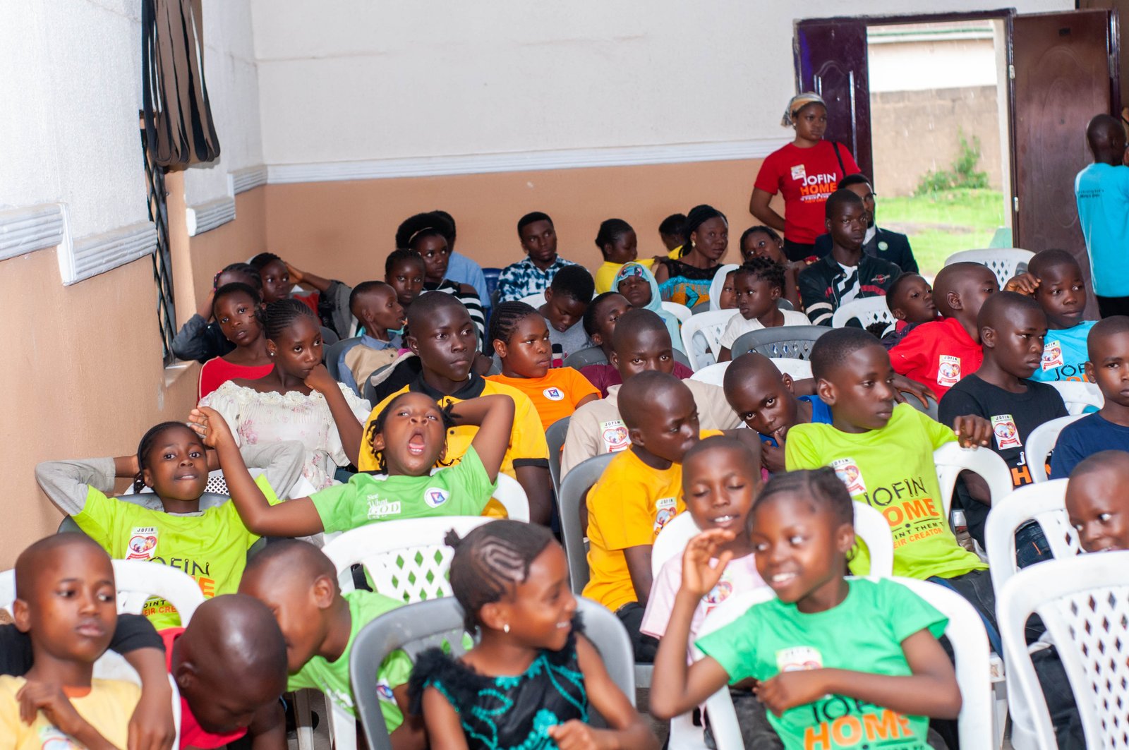 Children seated together at a JOFIN gathering, smiling
